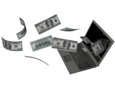 laptop with money blowing into it