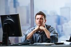 man in office with computer eyes closed