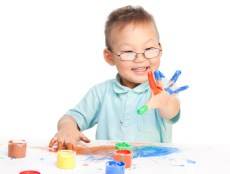 niño jugando con pinturas de dedos