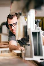 man with saw and safety glasses