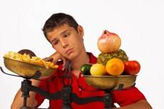 jongen overweegt slecht voedsel vs goed voedsel