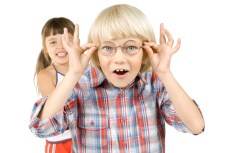 boy with glasses and girl behind him