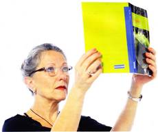 señora con libro alto para leer