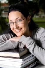 girl wearing glasses leaning on books